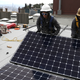 Workers install solar panels on the roof of a home on May 9, 2018 in San Francisco, California.